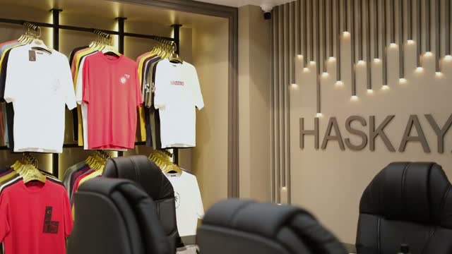 Showroomda renklerine göre dizilmiş tişörtler